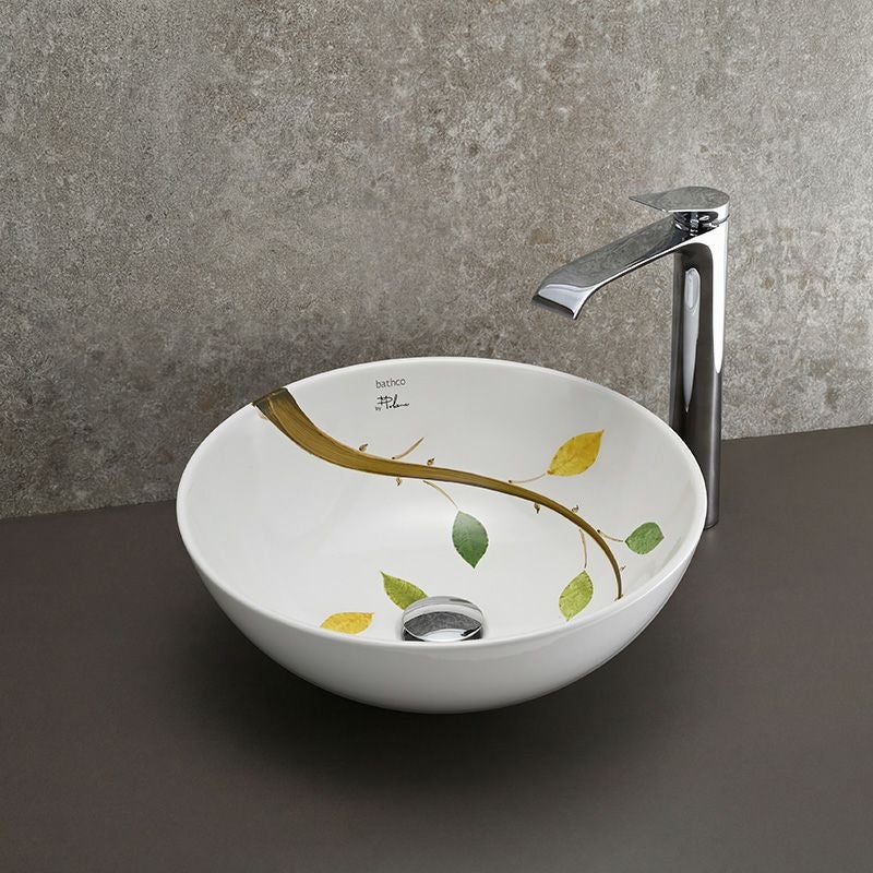 一筆書きのように描かれた枝葉が印象的な、BATHCO（スペイン）のアート陶器洗面ボウル。Φ400mm×H150mmのゆったりとしたサイズ感で、秋の情景を思わせる繊細な色彩が洗面空間に穏やかで詩的な雰囲気をもたらします。