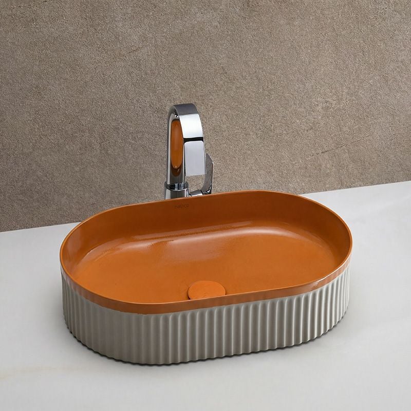 スペインBATHCOの陶器洗面ボウル「WADI Orange」。鮮やかなオレンジの内側とベージュグレーの外側のコントラストが印象的で、空間にぬくもりと彩りを添えるデザイン。オーバル型と釉薬の艶感が美しく調和し、住宅から商業空間まで幅広く活躍します。